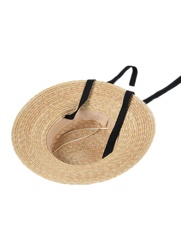 Cappello in rafia intrecciata con nastro nero