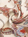 Close-up of a patterned fabric with red, blue, and beige colors on a white background.