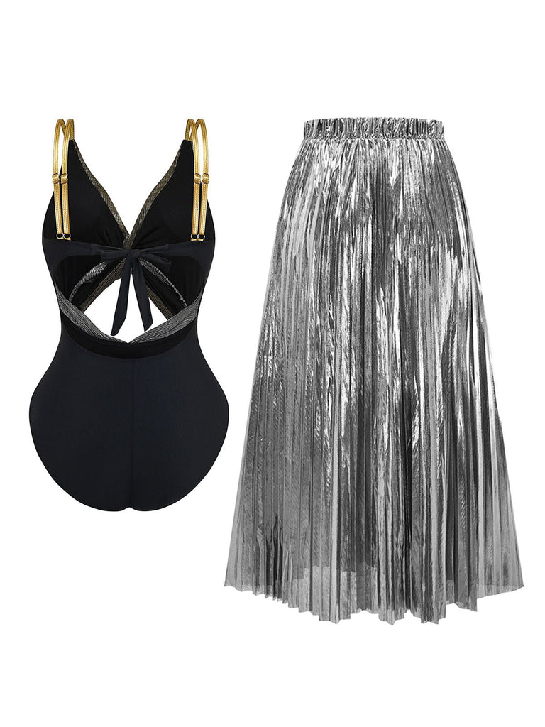 Black swimsuit with gold accents and silver pleated skirt on a white background