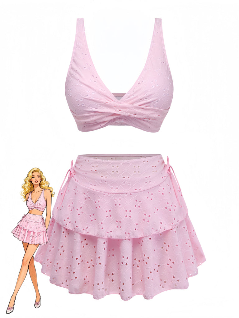 Completo composto da top e gonna bikini rosa con bambola che indossa l'abito su sfondo bianco