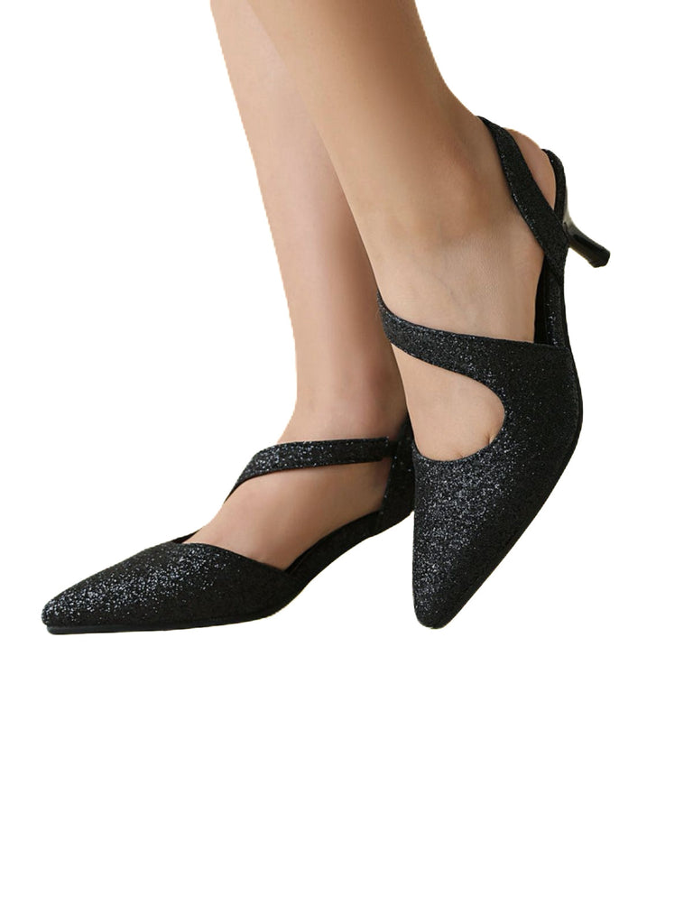 Black glittery shoes worn by a person on a white background