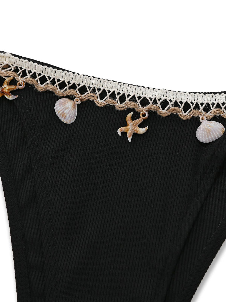 Black swimsuit bottom with lace trim and shell and starfish charms on a white background