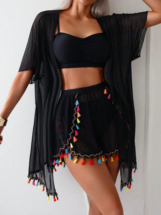 Black outfit with colorful tassels on a plain background