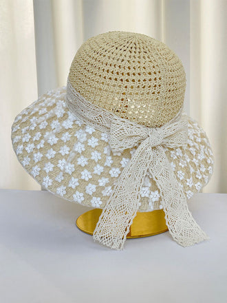 Cappello da sole beige con rifiniture in pizzo floreale bianco su sfondo bianco