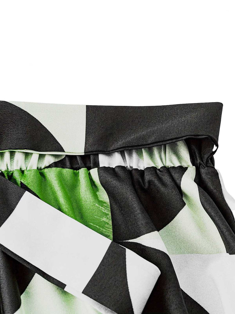 Close-up of a geometric patterned fabric with black, white, and green colors.