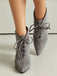 Gray suede pointed-toe shoes with laces on a neutral background