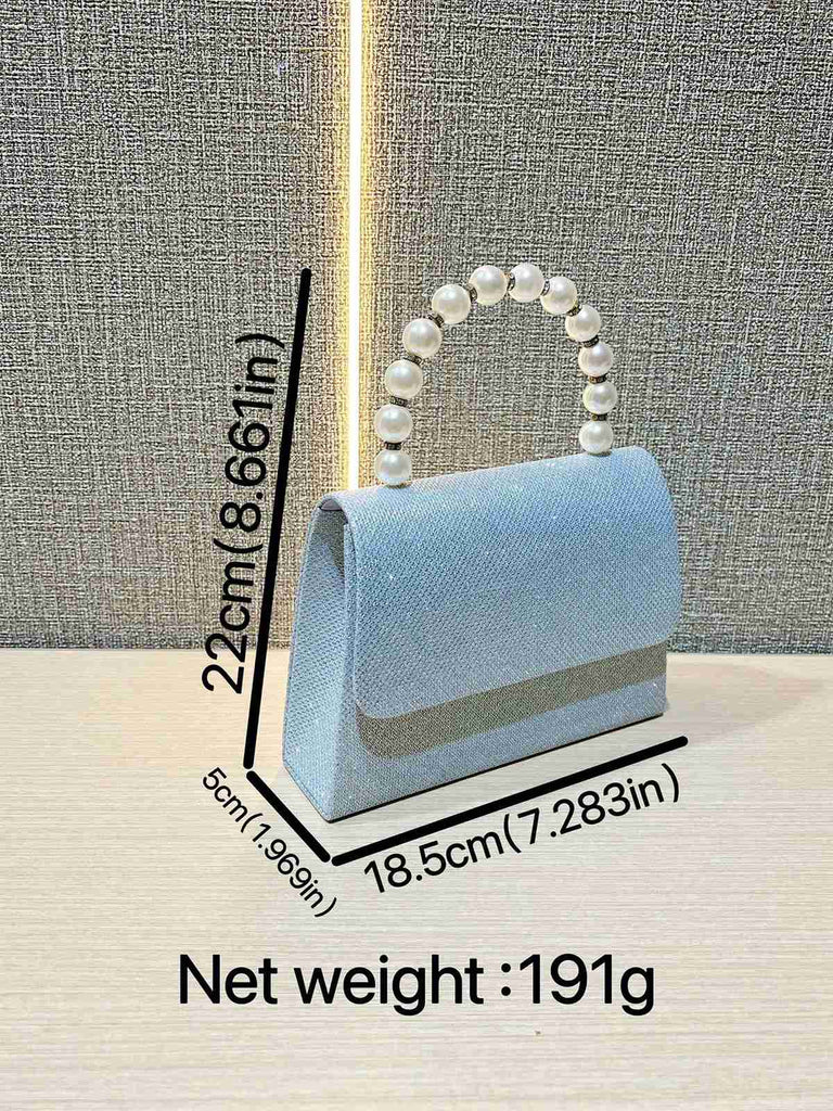 Light blue handbag with pearl handle on a textured gray background