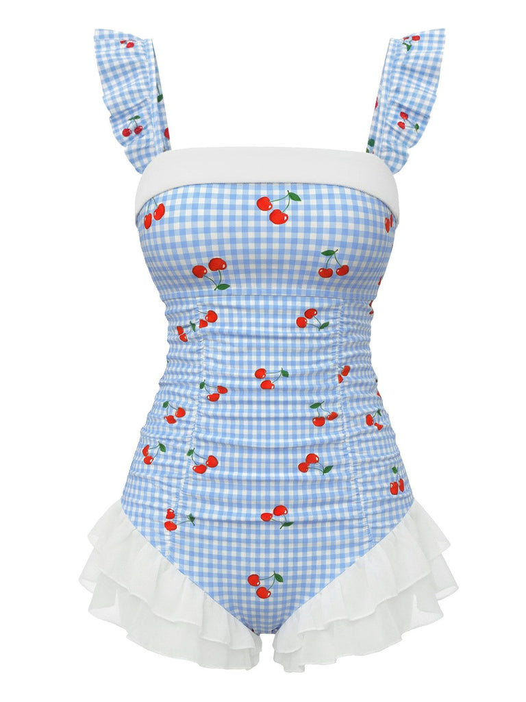 Vintage blue one-piece swimsuit with cherry plaid pattern and romantic ruffled mesh overlay, perfect for 1950s pinup-inspired beach styling