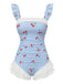 Vintage blue one-piece swimsuit with cherry plaid pattern and romantic ruffled mesh overlay, perfect for 1950s pinup-inspired beach styling