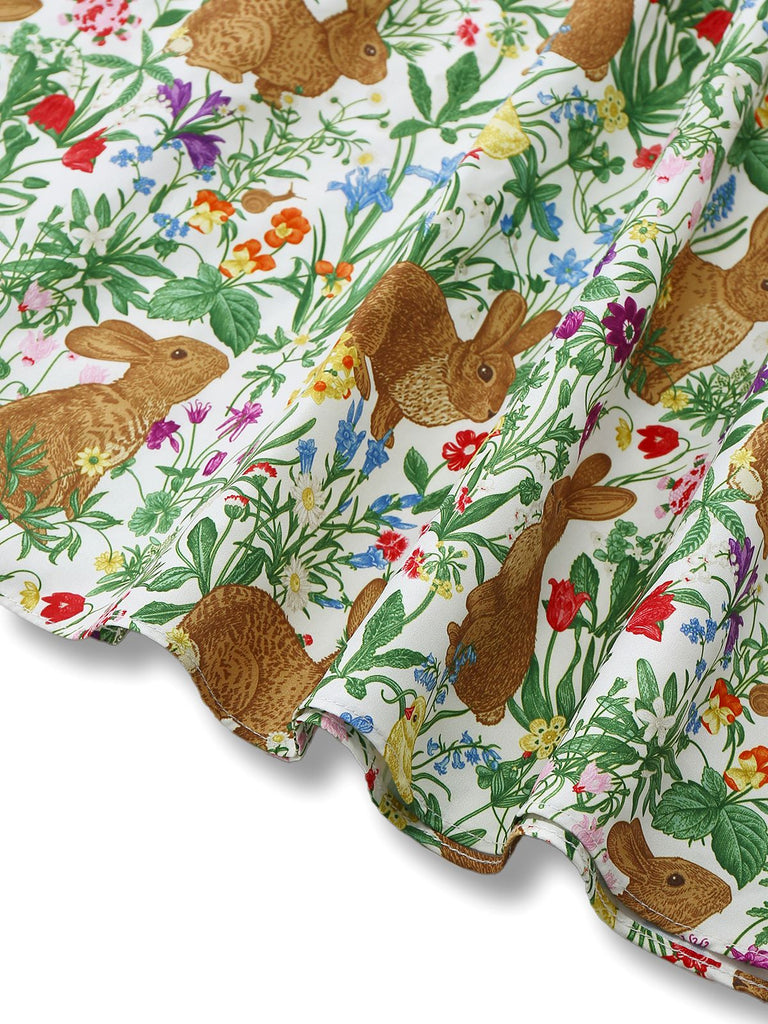 Close-up of the dress hemline showcasing the detailed print of brown rabbits among colorful spring flowers.