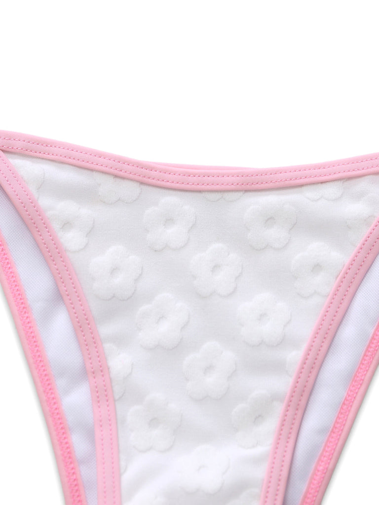 Close-up of the white bikini bottoms showcasing the subtle embossed daisy pattern and pink trim.