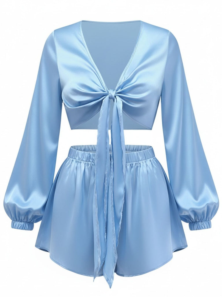 A light blue silky satin two-piece lounge set featuring a cropped tie-front top with long balloon sleeves and matching high-waisted shorts.