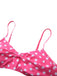 Close-up of the pink and white polka dot bikini top, showcasing the central bow detail and adjustable straps.