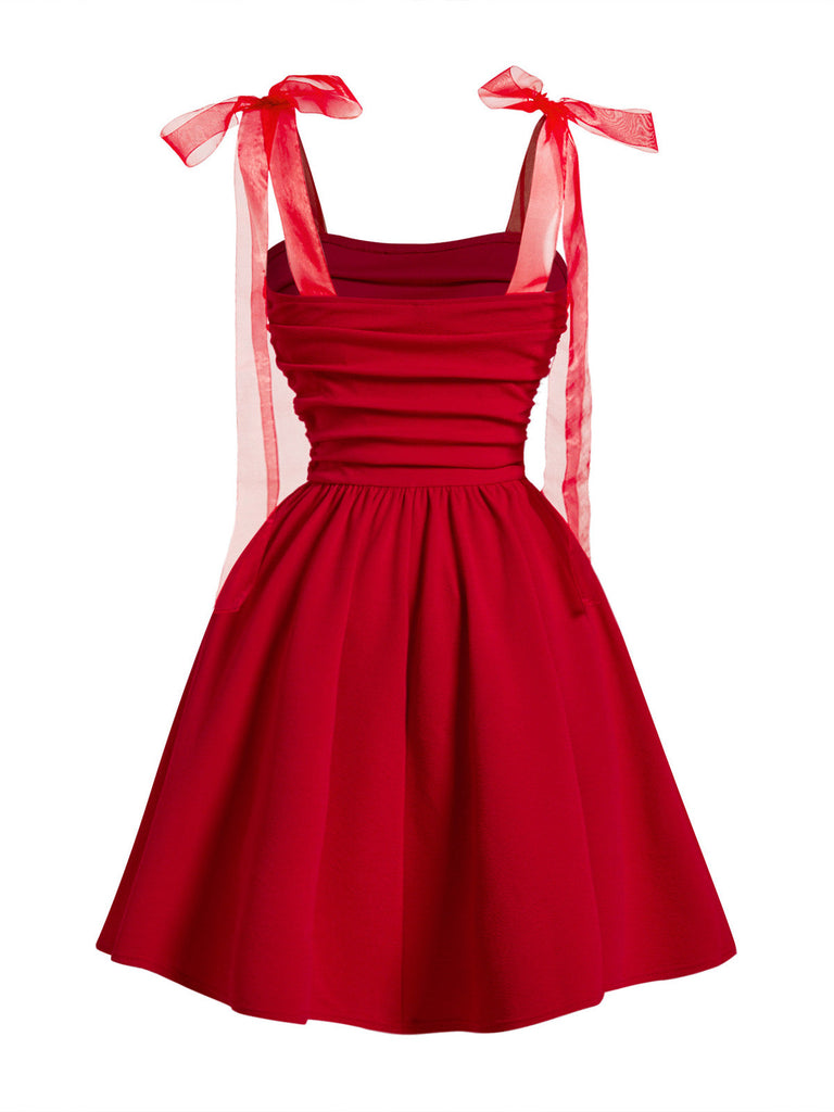 Rear view of the red fit and flare cocktail dress, highlighting the elegant silhouette and shoulder bow detail.