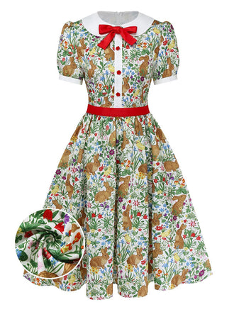 A vintage-inspired short-sleeve A-line dress featuring a whimsical bunny and wildflower print, a white Peter Pan collar, and a red bow accent.