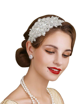 Woman wearing a decorative headband with pearls and earrings on a white background